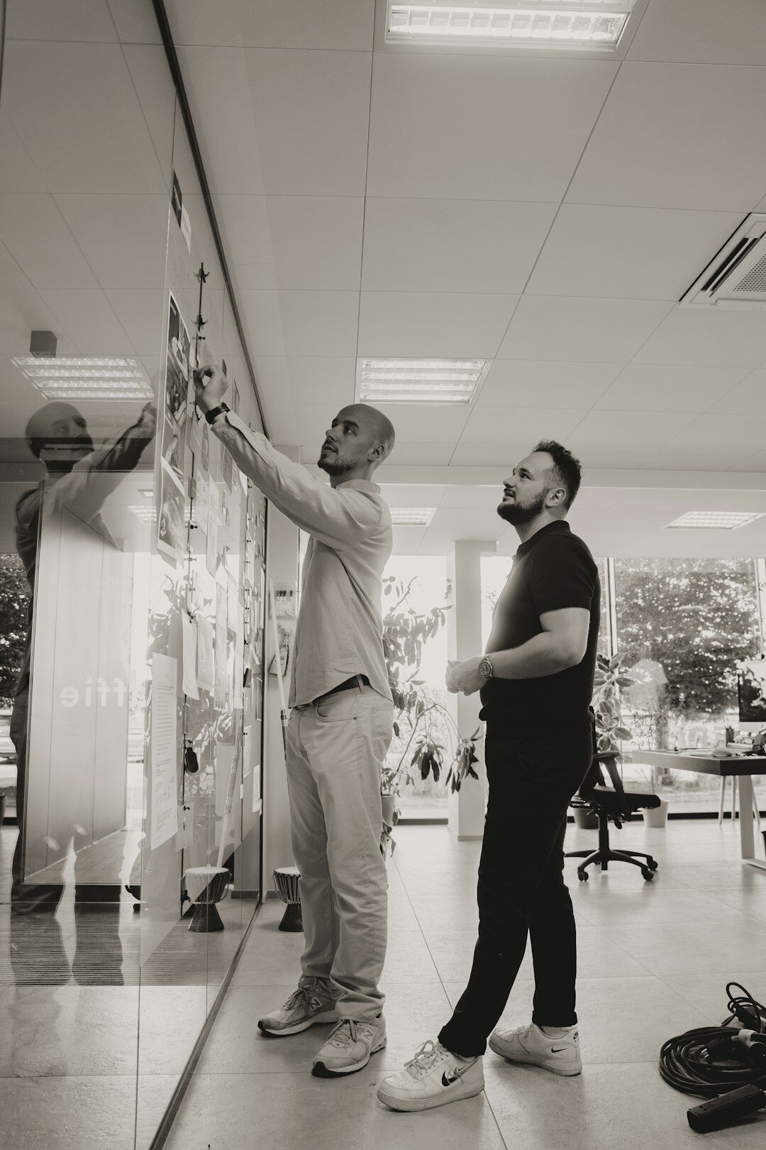 Belgian woman explaining a content calendar on a whiteboard to a colleague